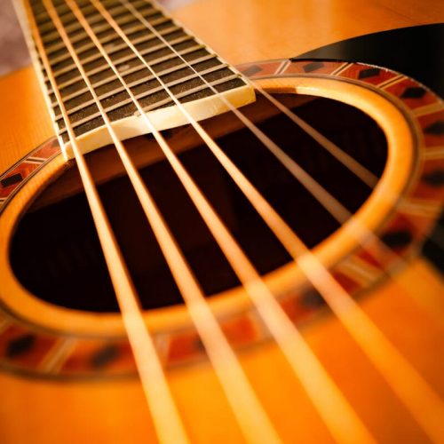 Stambiu planu akustinės gitaros stygos iš įstrižo kampo – fotografijos kursų užduotis 2A, mokinys Robertas B.